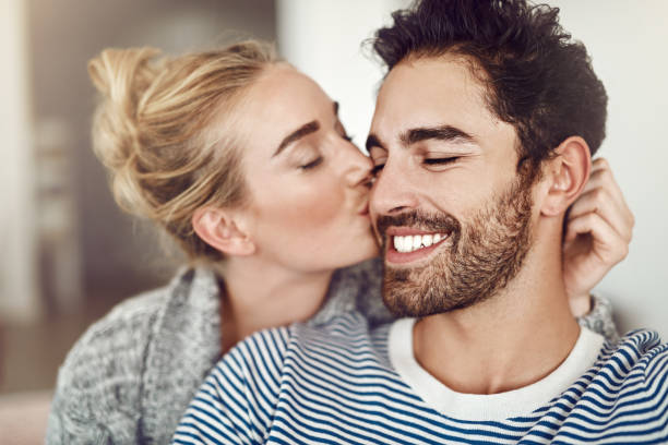 You're my everything, babe Cropped shot of an affectionate young couple relaxing at home cheek photos stock pictures, royalty-free photos & images