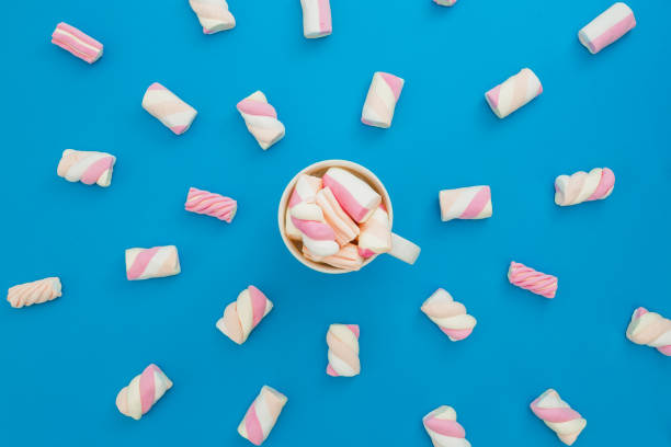 istock Cappuccino mug with marshmallows on blue background. Flat lay, top view 869674102