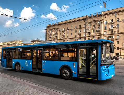 Blue bus on the street of a city.