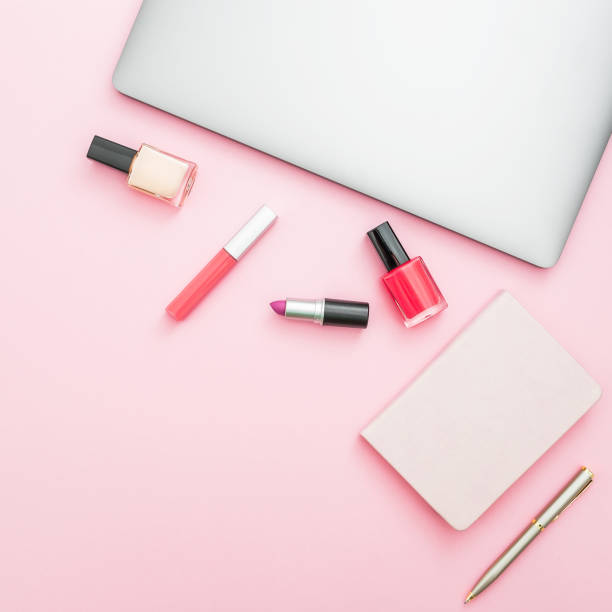 istock Feminine desk with laptop, notebook and cosmetics on pink background. Top view. Flat lay 869674876