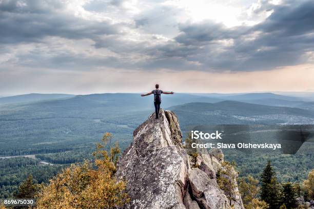 Ein Junger Mann Auf Einem Berggipfel Stockfoto und mehr Bilder von Berggipfel - Berggipfel, Klippe, Stehen