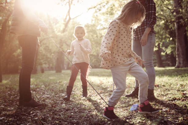 istock Family playing with rope in park. 869678328