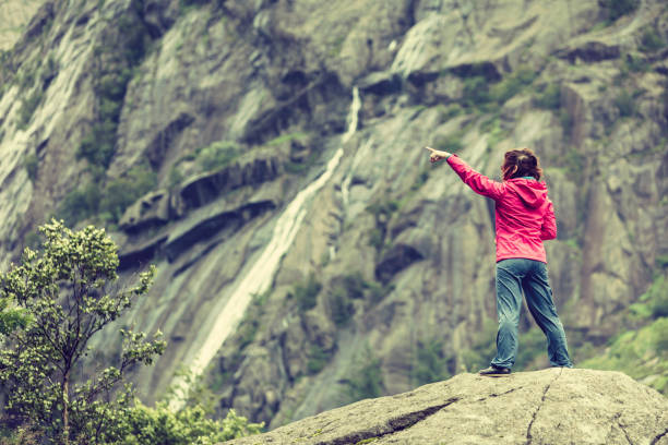 istock Woman on mountain rock enjoying beautiful view 869679150