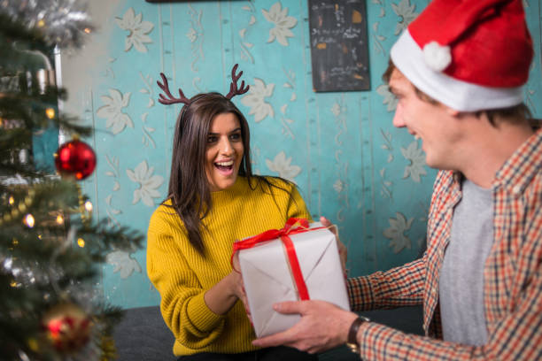 istock Friends celebrating Christmas: Giving presents 869686794