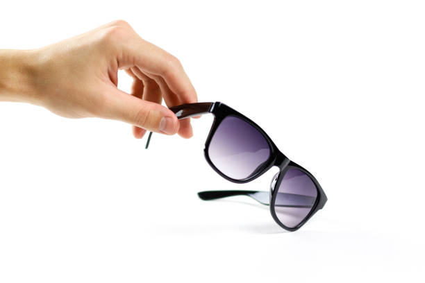 istock Hand holds black sunglasses. Isolated on white background 869693834