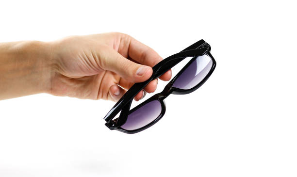 istock Hand holds black sunglasses. Isolated on white background 869693866