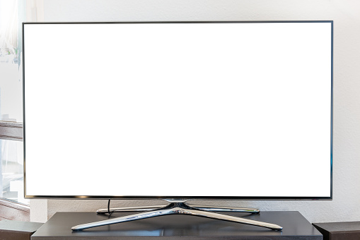 Blank white TV screen on a wooden stand in the living room from the front