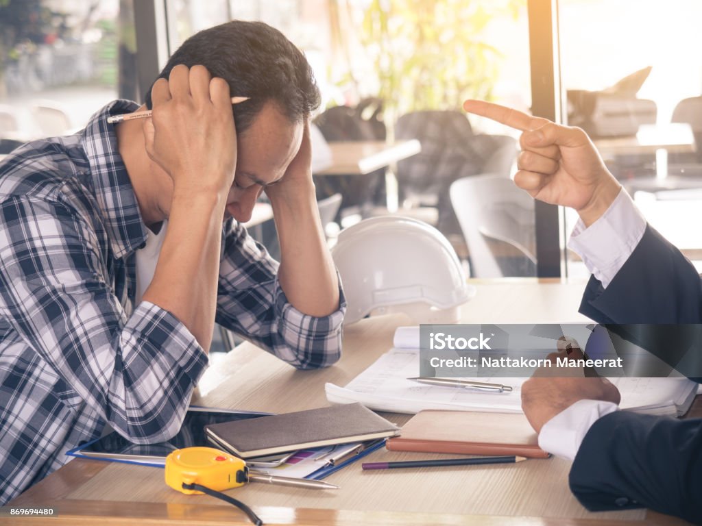 Boss/manager/businessman complaining to engineer/architect/employee by pointing to him for mistake work, stressed feeling Anger Stock Photo