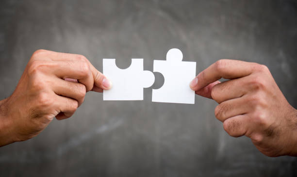 ジグソーパズル/チームワークの協力と連帯の概念を保持している実業家の 2 つの手 - jigsaw puzzle puzzle community meeting ストックフォトと画像