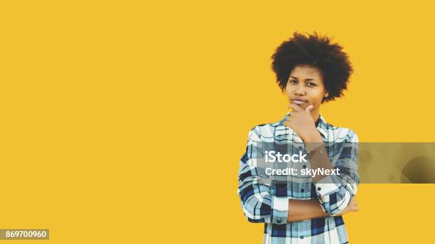 Pensive Brazilian Girl On Isolated Yellow Background Stock Photo - Download Image Now