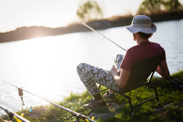 istock Men fishing in sunset and relaxing while enjoying hobby 869707358
