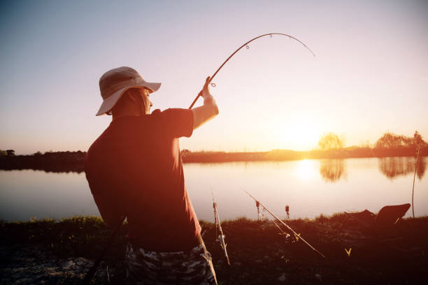 istock Men fishing in sunset and relaxing while enjoying hobby 869710136