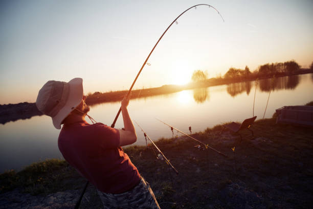 istock Men fishing in sunset and relaxing while enjoying hobby 869710180
