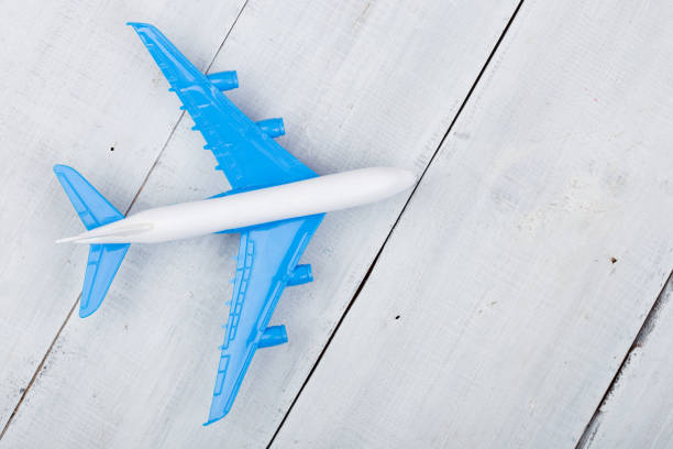 istock Toy plane on white wooden background. Top view 869733690