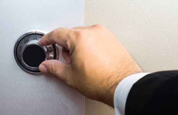 istock Hand wearing business suit turning safe dial lock. 869733940