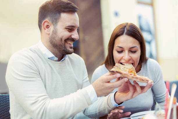 istock Love couple in a restaurant eating pizza. 869737184
