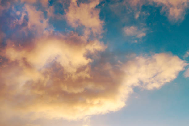 istock Bright yellow clouds on the blue sky at sunset or sunrise 869738160