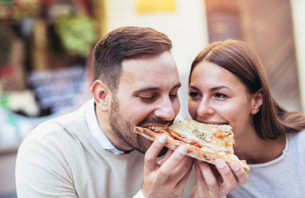 istock Love couple in a restaurant eating pizza. 869741034