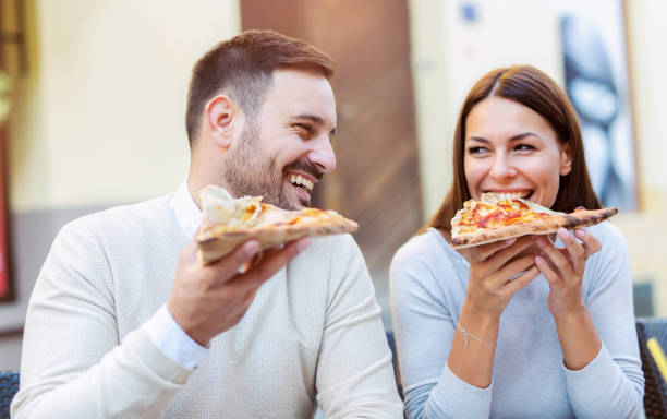istock Love couple in a restaurant eating pizza. 869741038