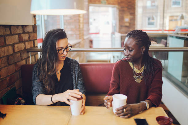 istock Young women sitting and talking at the coffee break 869746854