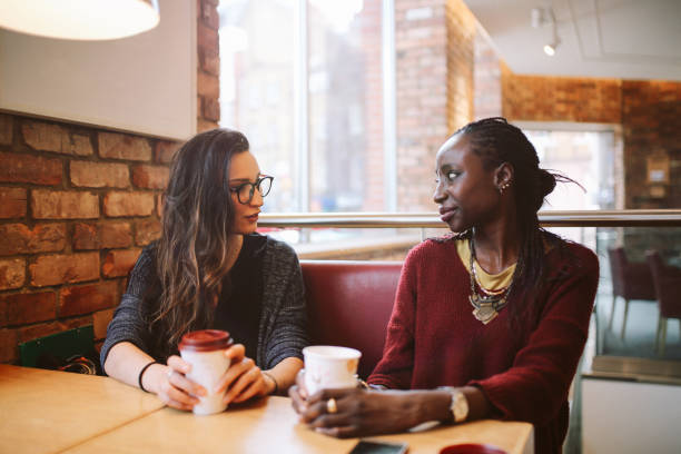 istock Young women sitting and talking at the coffee break 869747052