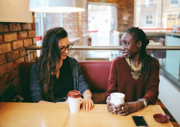 istock Young women sitting and talking at the coffee break 869747130