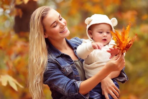 istock Mother with baby in the autumn park 869749934