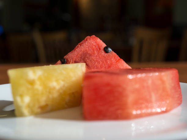 istock close up red watermelon and yellow pineapple. Placed in a white dish in a restaurant. 869756984