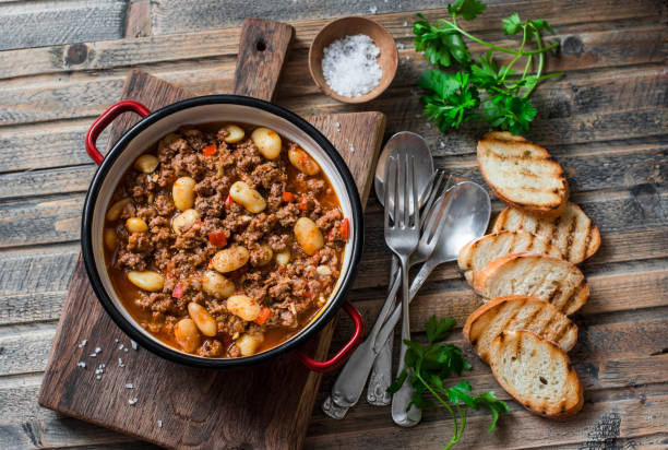 cannellini beans beef slow-cooker stew on the wooden table, top view. autumn, winter seasonal, healthy comfort food - food high angle view table stew imagens e fotografias de stock