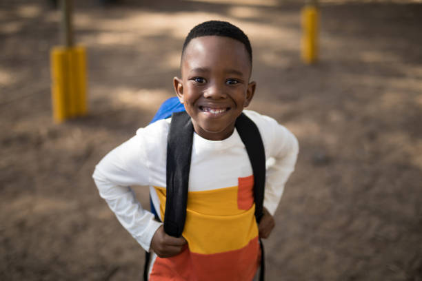istock Close-up of cute boy standing with school bag 869771902