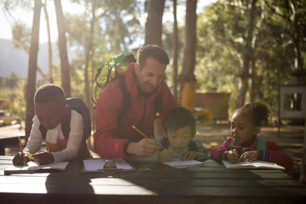 istock Teacher assisting kids in studying 869772132
