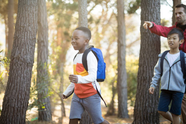 istock Teacher interacting with kids in park 869772424