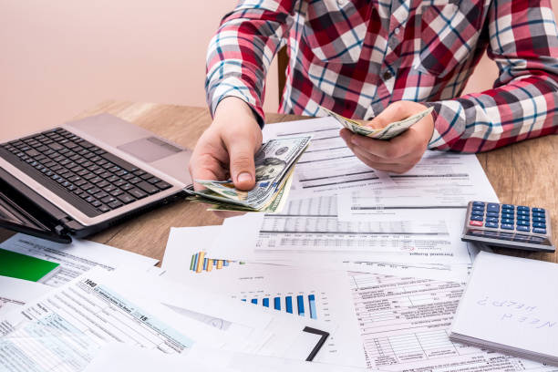 istock man counts money for office work and computer calculation of the budget 869772464