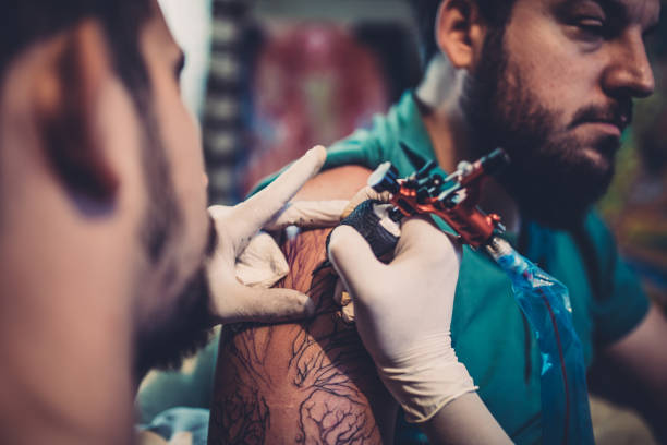 istock Artist tattooing a bearded man 869779840