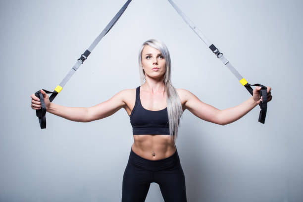 istock Sexy female fitness model training on a home training device in a studio 869785184