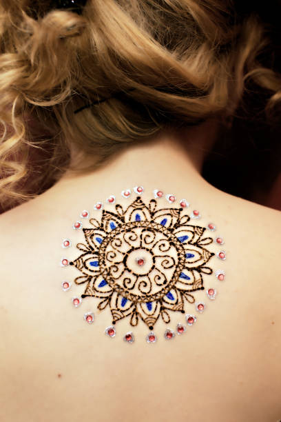 mehendi picture Hennaed beautiful female back, round mandala image, traditional Indian, Pakistani, African, Oriental motifs, cultural traditions and customs. Mehendi made of brown and orange henna paste. Professional back shoulder tattoos for women pictures stock pictures, royalty-free photos & images