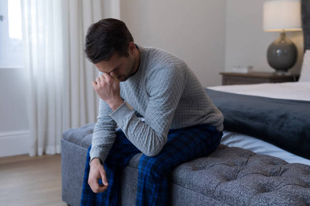 istock Tensed man sitting on bed 869798378