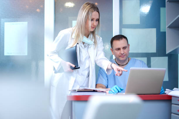 istock Nurse and doctor using laptop in medical clinic. 869801082