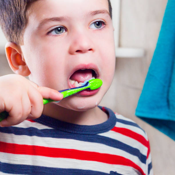 istock Young boy brushing his teeth with toothbrush 869801126