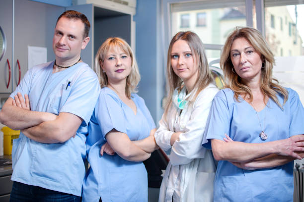 istock Group of dentists standing in dental office and looking at camera. 869801300
