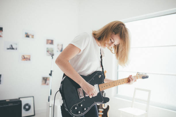 istock Young woman playing guitar 869801380