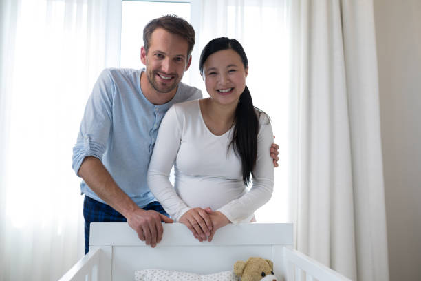 istock Happy couple standing near cot 869805526