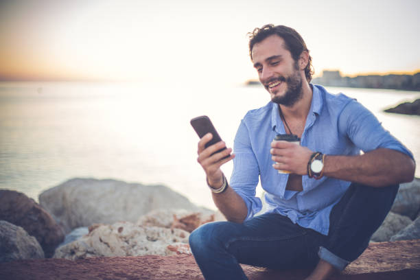 istock Smiling man relaxing at the beach 869805786
