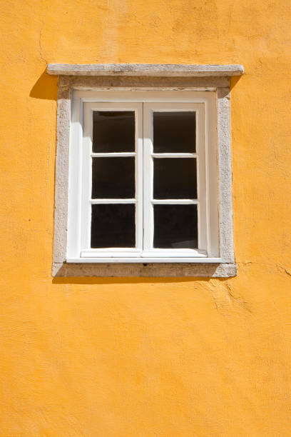istock Typical portuguese window against a colored plaster wall - image with copy space 869809894