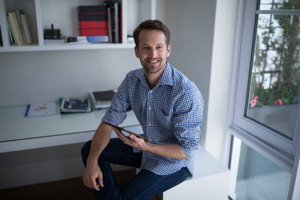 istock Portrait of man holding digital tablet 869814560