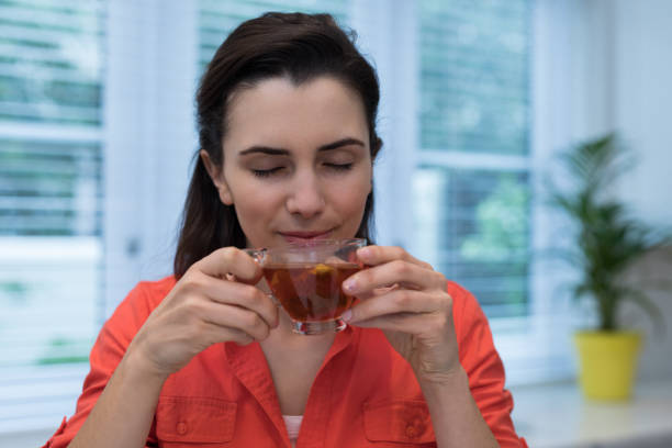 istock Woman having lemon tea in kitchen 869823244