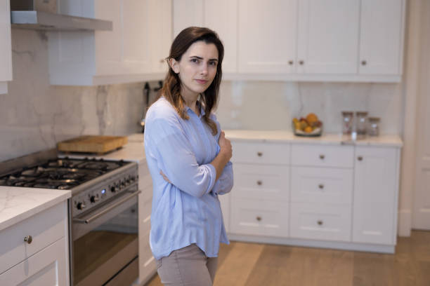 istock Woman standing in kitchen at home 869825508