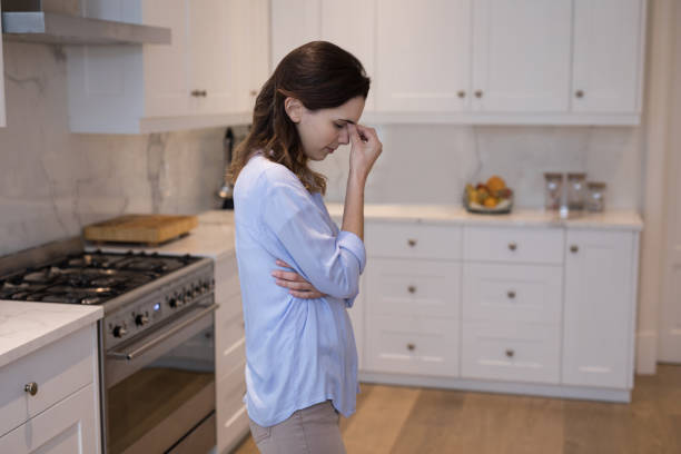 istock Worried woman standing in kitchen 869825520
