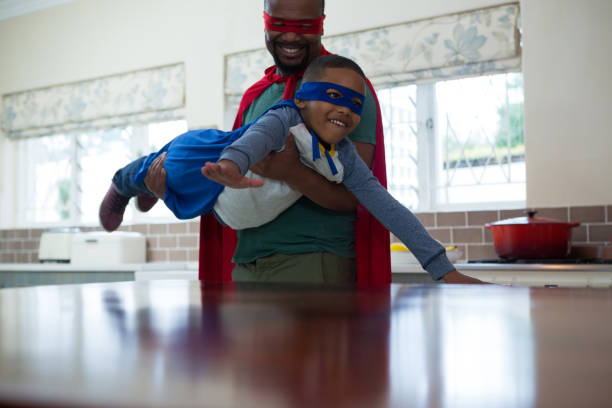 istock Son and father pretending to be a superhero in kitchen 869829666