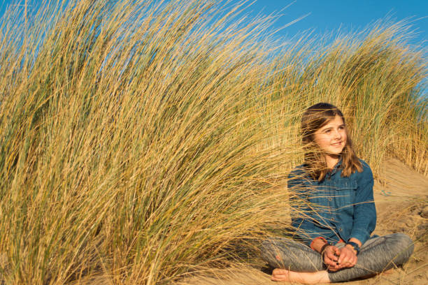 istock Child smiling amongst the sand dunes 869834082